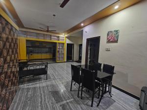 uma sala de jantar com uma mesa e cadeiras num quarto em 2Bhk holiday home em Mysore
