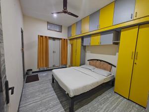 um quarto com armários amarelos e uma cama nele em 2Bhk holiday home em Mysore