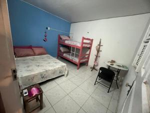 a bedroom with a bed and a table and a chair at Frida Hostel in Jericoacoara
