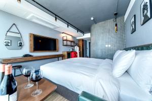 Marevo Beach Hotel في جيجو: غرفة نوم مع سرير وطاولة مع كؤوس للنبيذ