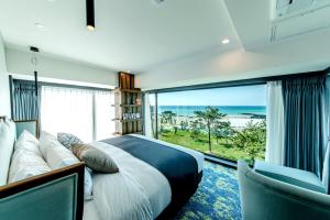 ein Schlafzimmer mit einem großen Bett und einem großen Fenster in der Unterkunft Marevo Beach Hotel in Jeju-do