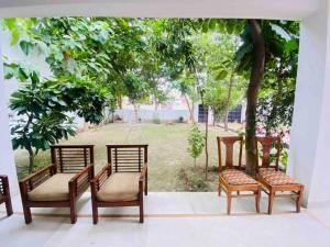 un gruppo di sedie sedute accanto a un albero di Luxurious Beautiful House Sector 70 noida a Noida