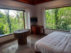 a bedroom with a bed and a large window at kurinjiyil Farm Stay Munnar in Munnar