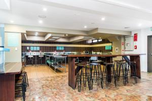 a large kitchen with a large bar with stools at Aquarius Backpackers Resort in Byron Bay