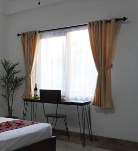 a bedroom with a desk and a window with a laptop at Balian Surf Club in Legian