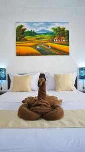 a towel animal is sitting on a bed at Balian Surf Club in Legian