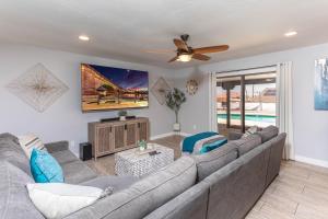 Una sala de estar con un sofá y un ventilador de techo. en HavaSunny Stay - Pool, Spa, Game Room, Fire Pit, en Lake Havasu City