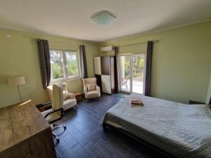 a bedroom with a bed and a desk and chairs at Villa Aberdeen in Tivat