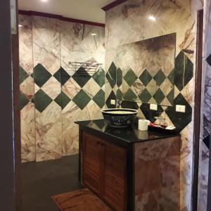 Prince Edouard Apartments & Resort SHA extra plus في شاطيء باتونغ: حمام مع حوض على منضدة ومرآة