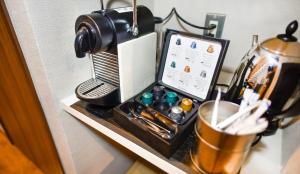 a table with a coffee machine and a tablet on it at Resort Yufuin - Grandpia Resort Yufuin in Yufuin