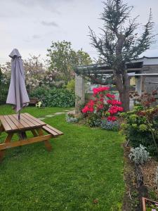 a picnic table with an umbrella in a garden at The Villa in Oamaru