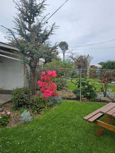 a garden with pink flowers and a picnic table at The Villa in Oamaru