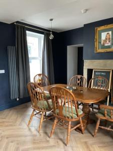 uma sala de jantar com uma mesa de madeira e cadeiras em Entire boutique mill cottage em Elland