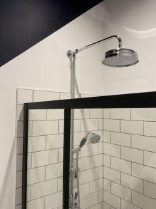 un baño con ducha con cabezal de ducha en Entire boutique mill cottage, en Elland