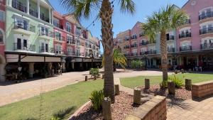 una fila de edificios con palmeras en un patio en Couples Getaway - Sweet Retreat - European Village Best Location, en Palm Coast