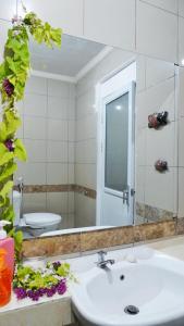 a bathroom with a sink and a mirror and a toilet at Balian Surf Club in Legian