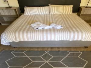 uma cama com duas toalhas em cima em Aloe Guest Rooms em Bloemfontein