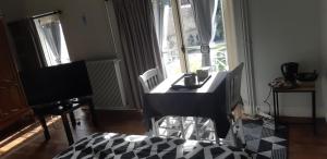 Zimmer mit einem Tisch, Stühlen und einem Fenster in der Unterkunft Chambres d'hôtes chez Sylvie in Donnemain-Saint-Mamès