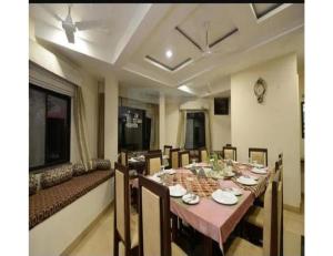 a dining room with a table and chairs and a couch at Hotel Sanginee, Maheshwar in Maheshwar