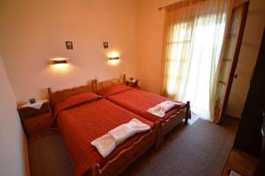 a bedroom with a bed with red sheets and a window at Felicita in Paleokastritsa