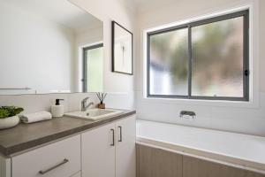 baño blanco con lavabo y ventana en Mountain Bike Haven, en Bright 15 fotos más