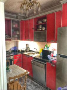 a kitchen with red cabinets and a table in it at In the city center, near metro, Şişli, Nişantaşı in Istanbul