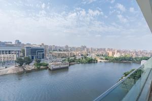 a view of a river with a boat on it at Brassbell l Nile view serviced apartments in zamalek in Cairo