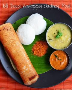 a plate of food with rice and a roll and sauce at Hotel Ananya Inn in Varanasi