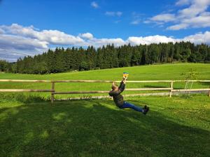 een persoon die springt om een frisbee te vangen in een veld bij Bauernhof Mittereibenberger in Liebenau
