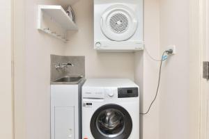 uma lavandaria com uma máquina de lavar roupa e um lavatório em Villa 2br Madeira Villa located within Cypress Lakes Resort em Pokolbin