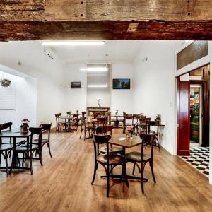 a restaurant with tables and chairs in a room at Beachside Budget Rooms in Kiama