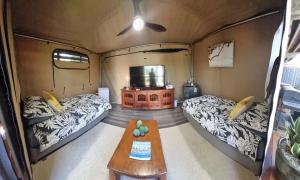 una habitación con 2 camas y una mesa en una caravana en Birdsong Retreat BnB on Lamb Island, 