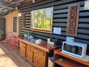 cocina con microondas sobre una mesa de madera en Birdsong Retreat BnB on Lamb Island, 
