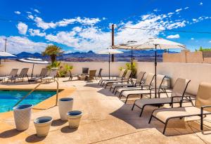 a patio with chairs and umbrellas next to a pool at LakeView Home Minute From New Launch With Pool And Spa in Lake Havasu City