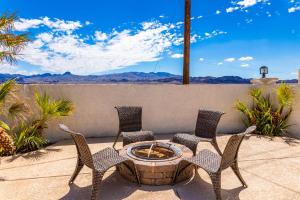 a patio with four chairs and a fire pit at LakeView Home Minute From New Launch With Pool And Spa in Lake Havasu City