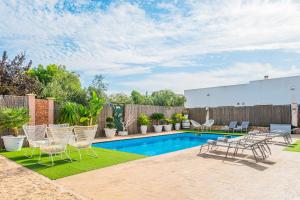 une cour avec une piscine, des chaises et une clôture dans l'établissement Villa Sueños, à Marratxí 