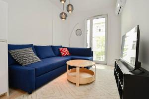 un canapé bleu dans un salon avec une table dans l'établissement New modern apartment in city center, à Bratislava