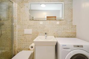 une salle de bain avec un lavabo et une machine à laver dans l'établissement New modern apartment in city center, à Bratislava 5 autres photos