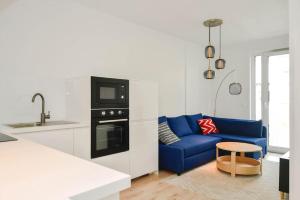 un salon avec un canapé bleu dans une cuisine dans l'établissement New modern apartment in city center, à Bratislava