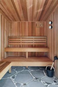 a sauna with wood paneling and a black pot at Months and Seasons Design-led Country House in Daylesford