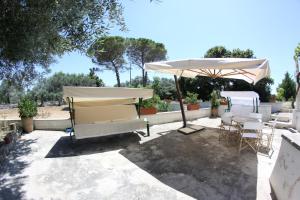 a patio with a table and an umbrella and chairs at B&B Casale Spisari in Galatone