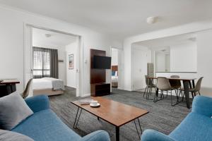 a living room with a blue couch and a table at Quest West End in Perth