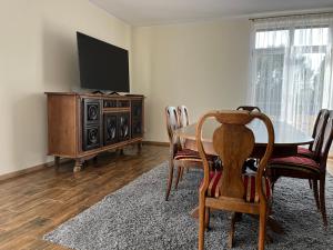 een eetkamer met een tafel en een flatscreen-tv bij Zajazd u Piasta Kołodzieja in Kruszwica