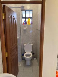 een kleine badkamer met een toilet en een raam bij Nomi's Nook1 B-room rental unit free parking in Nakuru CBD in Nakuru