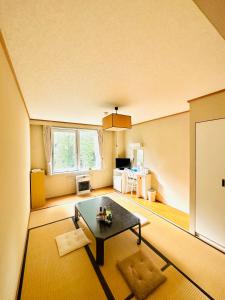 a living room with a table and a window at HOTEL JUSTICE Ski IN-Ski OUT in Seki