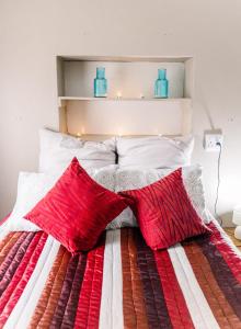 a bed with red and white blankets and pillows at Stamvrug 9 B in Nelspruit