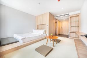 a bedroom with a bed and a table at LiveZen Bangkok Sukhumvit in Khlong Toei +37 photos