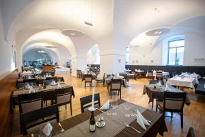 um restaurante com mesas e cadeiras num quarto em Hotel Altes Kloster em Hainburg an der Donau