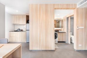 a kitchen with a door open to a room with a kitchen at LiveZen Bangkok Sukhumvit in Khlong Toei