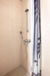 a shower with a shower curtain in a bathroom at 2ndhomes Bright & Compact Studio with the best loc in Helsinki